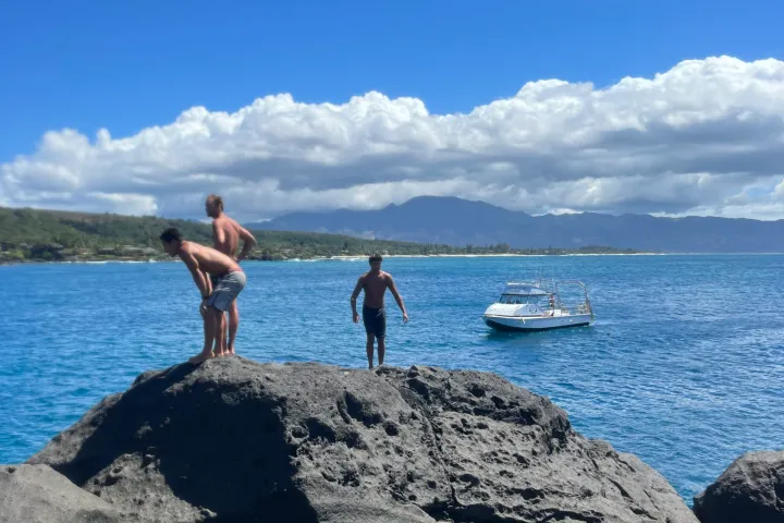 a person standing on a rocky beach next to a body of water