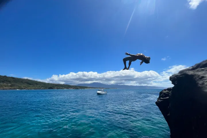 a man flying through the air over a body of water